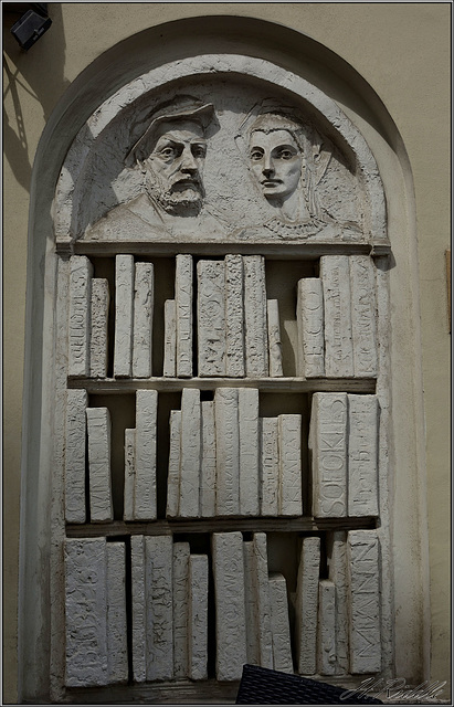 Stone book carvings in Krakow house wall.