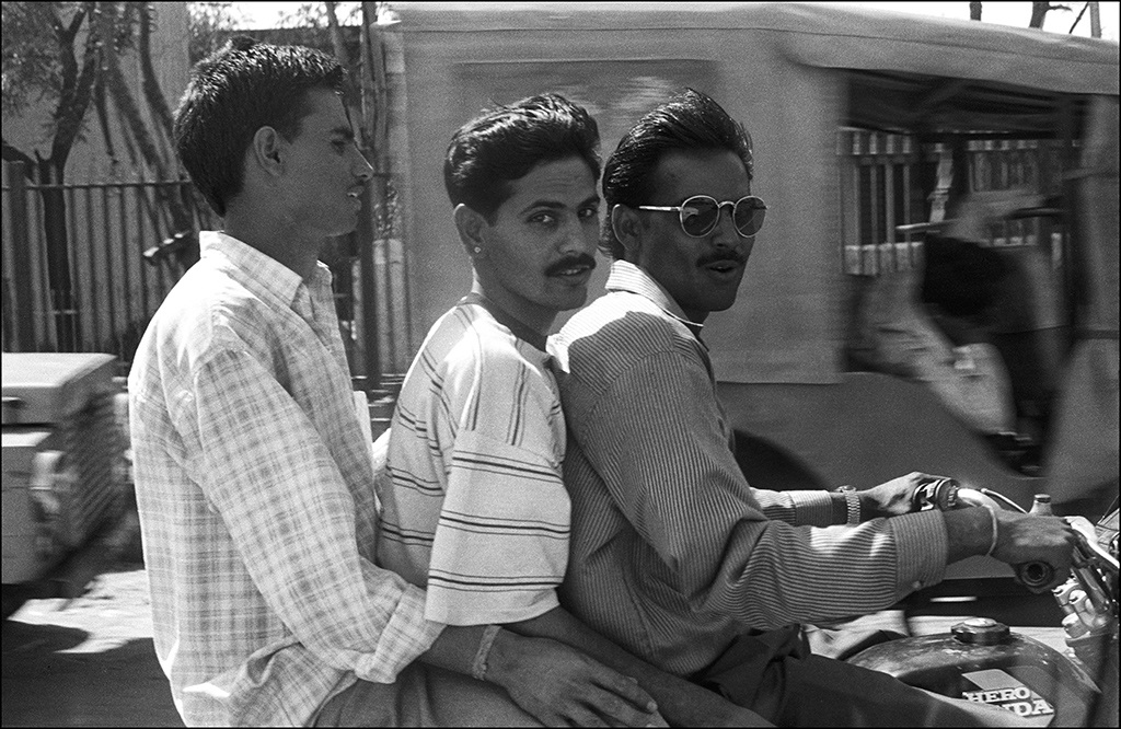 Three men on a motorcycle .