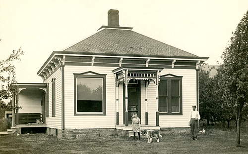 Girl, Dog, and Man in Front of a House