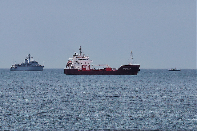 HUNT-class mine countermeasures vessel HMS Hurworth (M39) and oil products tanker Fredericia, 3.5 nm out in Weymouth Bay on a gloomy morning