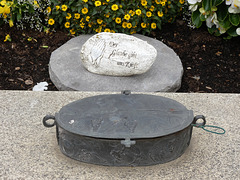 Weihwasserkessel und Gedenkstein