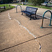A bench, a crack, and bicycle racks