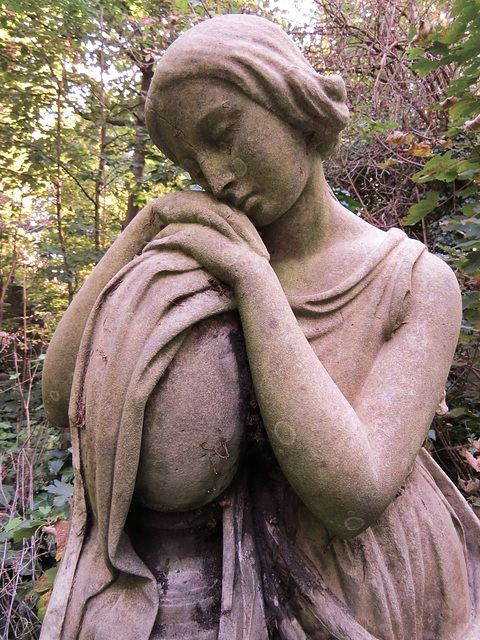 abney park cemetery, stoke newington, london,mourner on early c20 grave, the epitaph buried in undergrowth