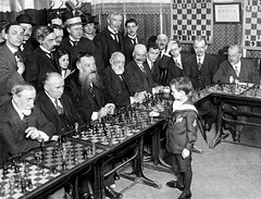 Niño ajedrecista jugando con adultos