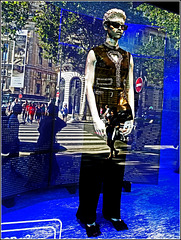 Vitrine avec mannequin et reflets de la ville