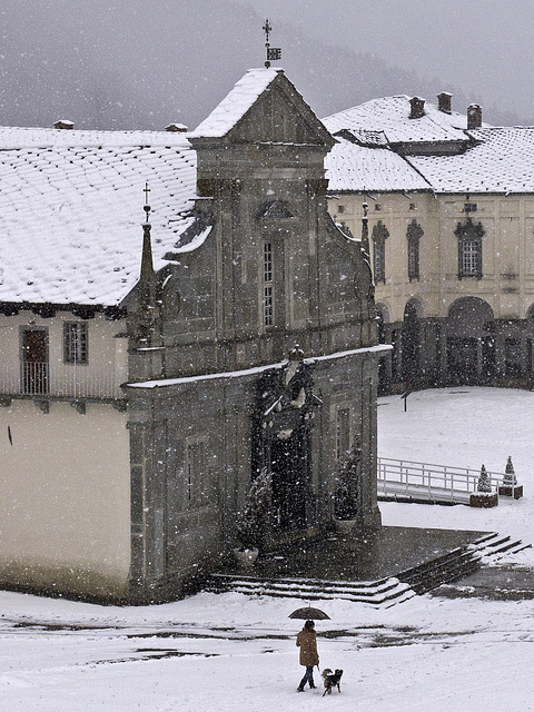 A walk under the heavy snow in front of the Old Basilica of Oropa, Biella, Italy