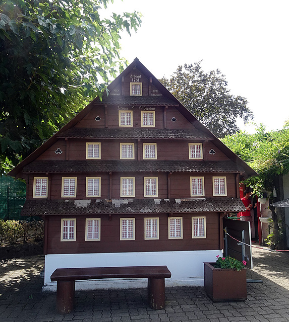 Grosse Sitzbank vor kleinem Haus