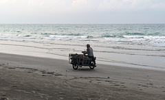 Un motocycliste au travail sur la plage / Beach worker on wheels
