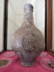 michelham priory, sussex   (19)c17 bellarmine found used as a witch bottle c.1666 when it was buried upright outside the west porch of the cloister with pins and perhaps a wax heart within