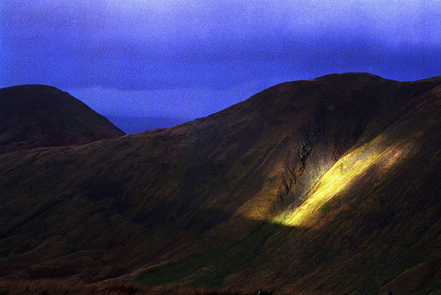 Black clouds descend but leave a ray of sunshine on the slopes of The Knott (739m) (Scan from 1994)