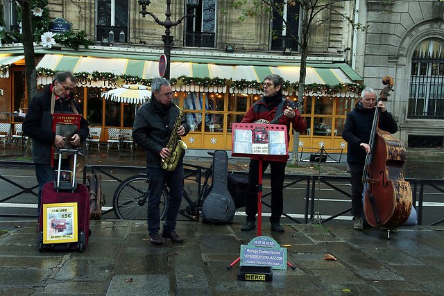 Musiciens de rue à Paris , de bonne humeur malgré la pluie et le vent  . .