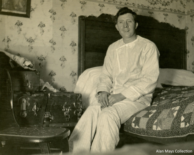 Pajama-Clad Man Sitting on a Quilt-Covered Bed