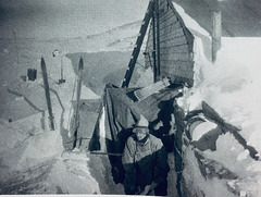 Edward "Marie" Nelson digging out the hut after a blizzard