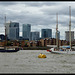 Two tall ships passing in front of Canary Wharf