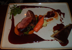 Roast duck with potato pie and vegetables.