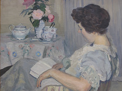 "Alice lisant à côté d'une tasse de thé"