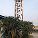 Château d'eau et jeunes palmiers / Water tower along with young palm trees