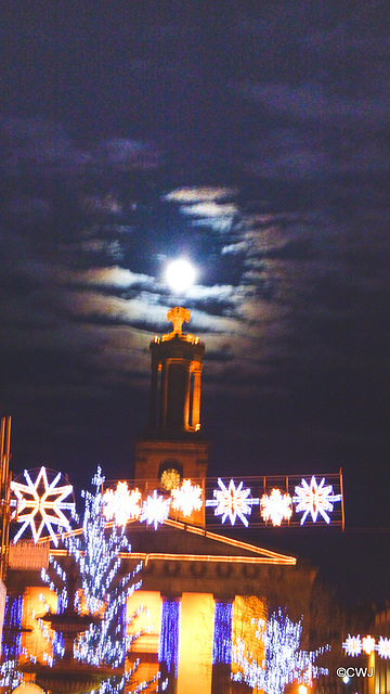 The moon rising over the steeple of St Giles Church Elgin and its Christmas decorations.