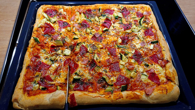 Pizza mit Gemüse, Salami, Schinken, Mozarella und aus eigenen Tomaten eingekochtes Sugo