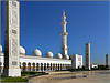 AbuDhabi : esterno del grande cortile al sole del mattino - un minareto ad angolo e tre obelischi delimitano l'area sul lato di levante