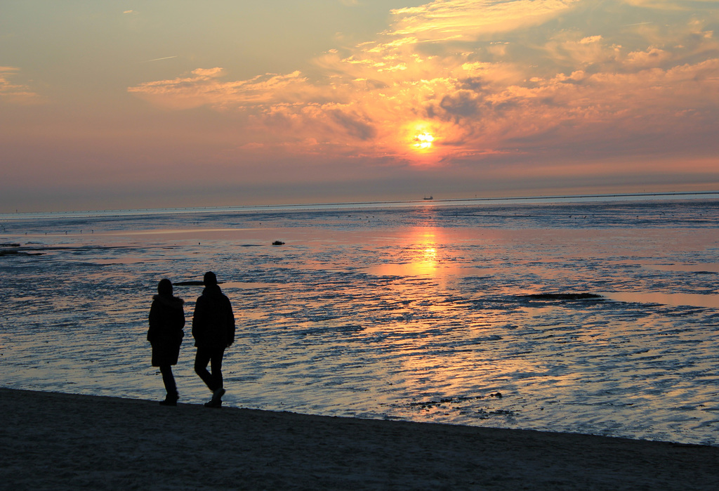 Spaziergang am Strand bei untergehender Sonne