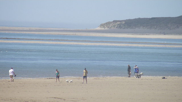 Tide was coming in and people were enjoying the sun
