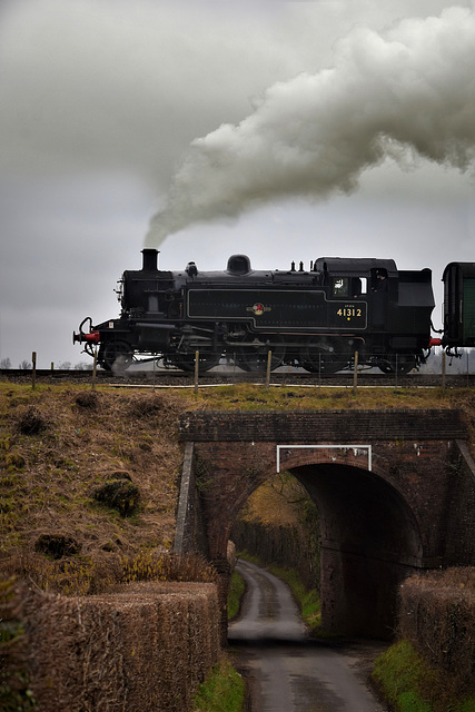 Locomotive crossing a bridge with some fences so workers don't fall.