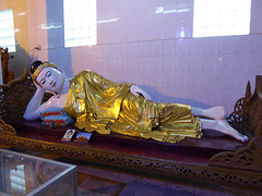 Buddha liegt gestützt von Kissen