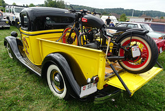 Ein Gelb-schwarzes Schmuckstück beladen mit einem Triumph Motorrad