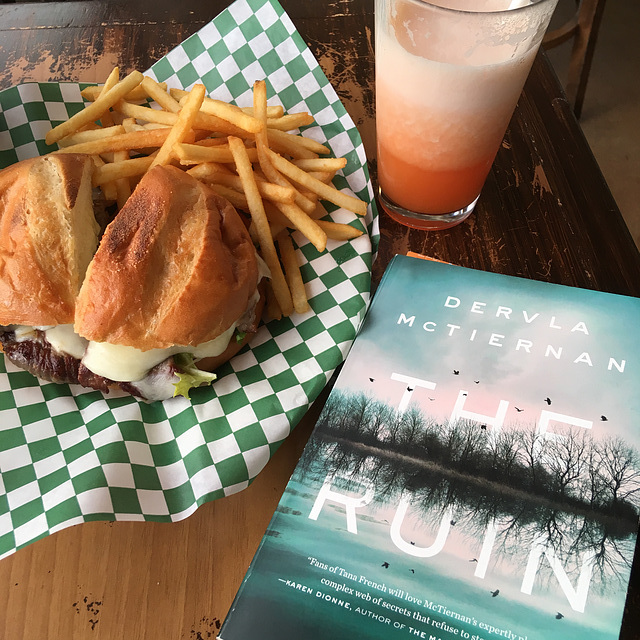 Reading with sandwich, fries, juice