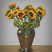 A bouquet of sunflowers in a silver vase