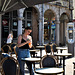 Empty tables and a lady applies sun-cream!