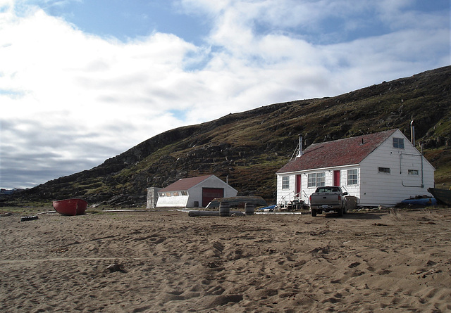 Maisons inuits entre sable et ciel bleu