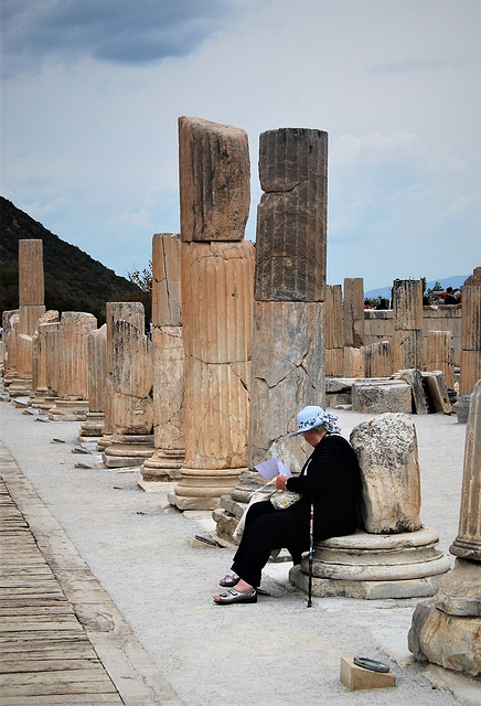 Lady sitting on a stone bench