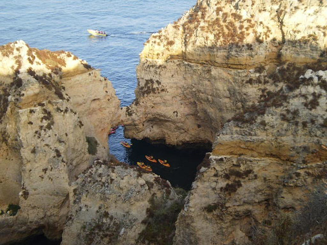 Canoes exploring rocky coast.