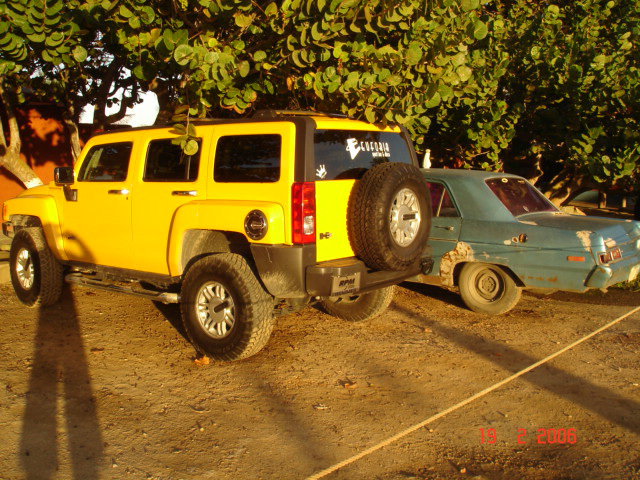 Yellow Hummer and rusty car