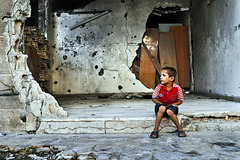 boy outside a shattered home