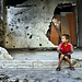 boy outside a shattered home