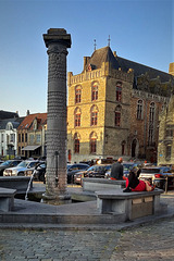 Lady in red dress lying on a stone bench.