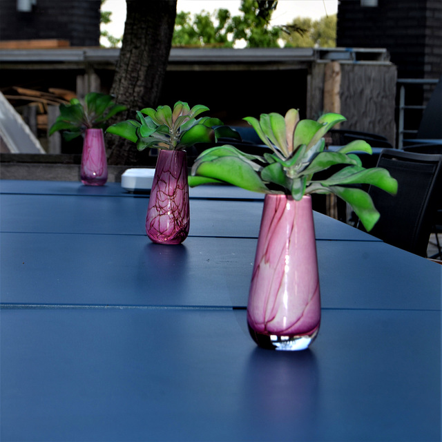 Three purple vases on a table