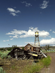 Burned house, standing house, water tower