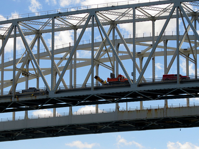 A tiny worker on a large bridge