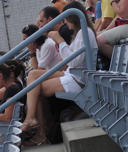 White short pants and golden straps sandals crossed legs Lady