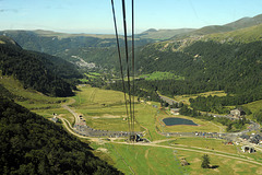 Du haut du téléphérique du Puy de Sancy la vue plonge  sur la vallée de la rivière la Dogne. Au fond la ville station thermale du Mont Dore.
