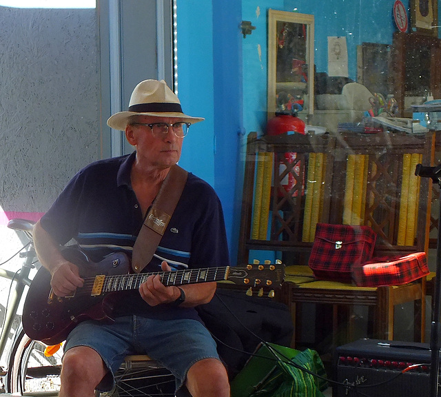 Commerçant agayant de ses notes de musique devant sa boutique (Marché de St Foy la Grande (33)