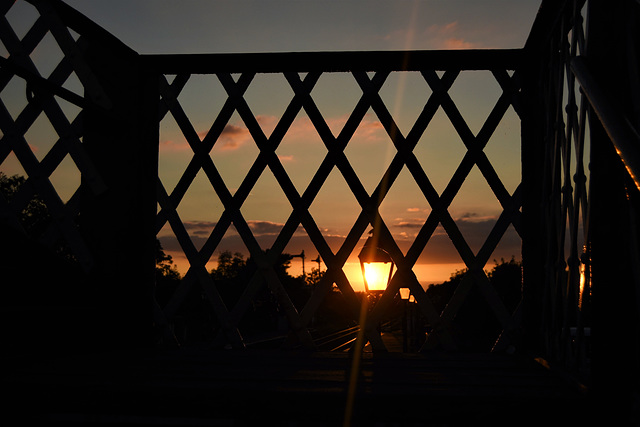 Is this a streetlamp visible through a fence?  HFF