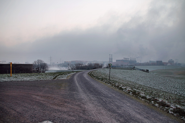 Weg auf dem Rheindamm, im Hintergrund das Stahlwerk Beeckerwerth (Duisburg-Bruckhausen) / 17.12.2022