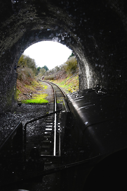 Driving a railway locomotive inside the black walls of the tunnel.