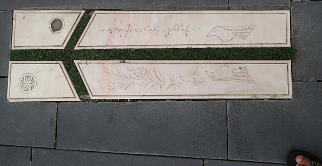 A marble gravestone marked with St Nino's cross in grass