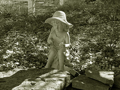 Statue Of A Girl Sitting In A Garden